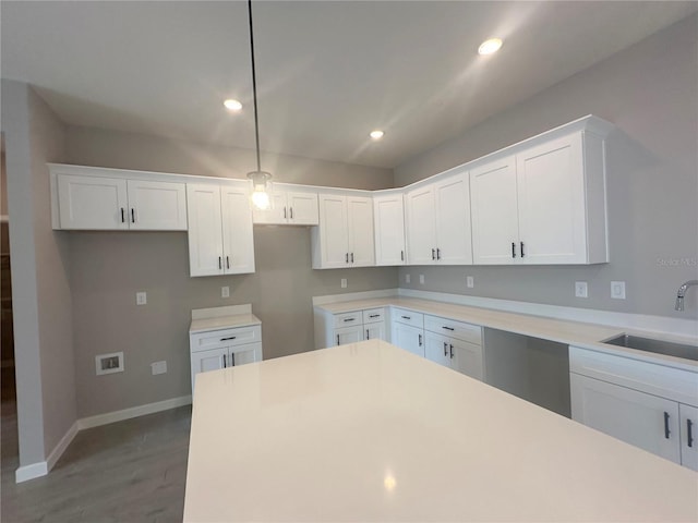 kitchen featuring sink, hardwood / wood-style flooring, white cabinets, and decorative light fixtures