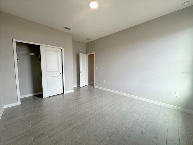 unfurnished bedroom featuring hardwood / wood-style flooring and a closet