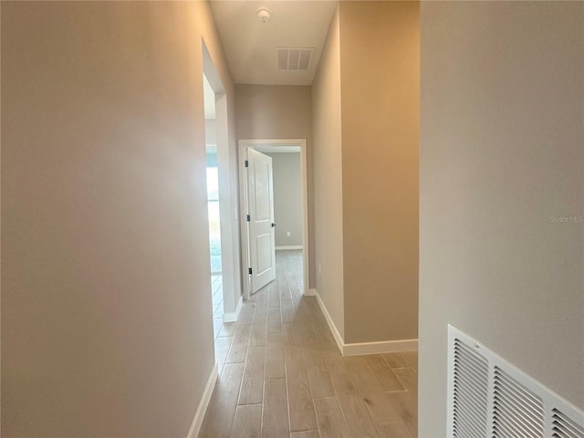 hallway with light hardwood / wood-style floors