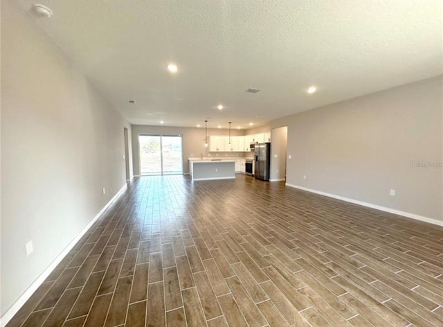 4501 SW 110th Ln, Ocala, FL 34476 - unfurnished living room with dark wood-style flooring, recessed lighting, and a textured ceiling