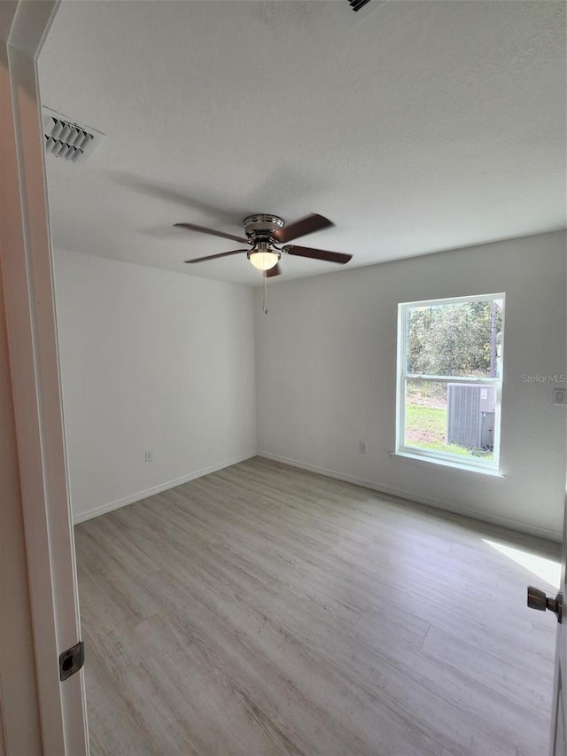 unfurnished room with light wood-style floors, baseboards, visible vents, and ceiling fan