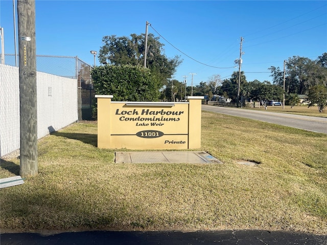 community sign featuring a lawn