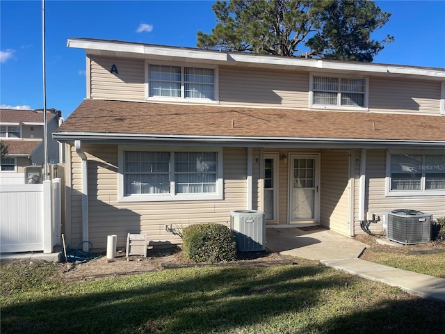 view of front facade featuring a front lawn and central air condition unit