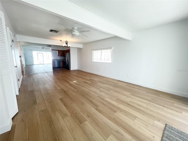 unfurnished living room featuring a textured ceiling, beamed ceiling, ceiling fan, and light hardwood / wood-style flooring