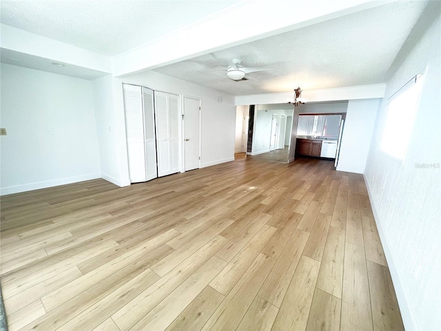 unfurnished living room featuring ceiling fan, light hardwood / wood-style floors, and a textured ceiling