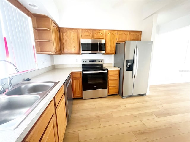 kitchen featuring appliances with stainless steel finishes, light hardwood / wood-style flooring, and sink