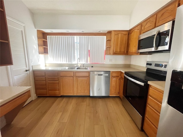 kitchen with sink, stainless steel appliances, and light hardwood / wood-style flooring