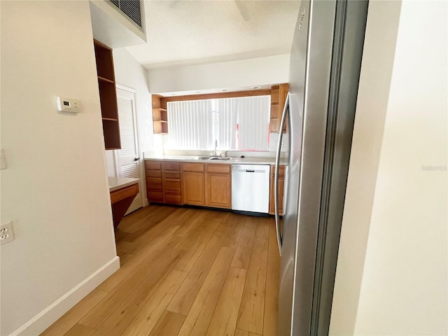 kitchen featuring light wood-type flooring, appliances with stainless steel finishes, and sink