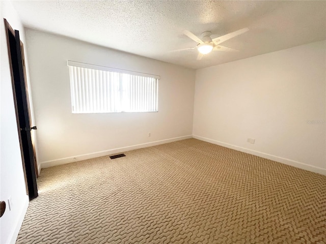 empty room featuring a textured ceiling, carpet flooring, and ceiling fan