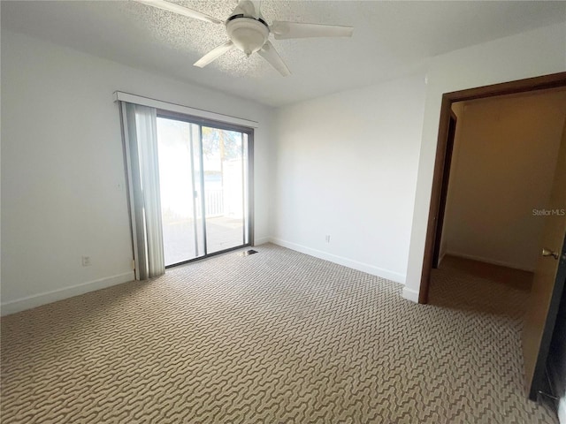 carpeted empty room with ceiling fan and a textured ceiling