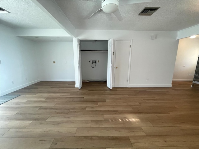 bonus room with light wood-type flooring, a textured ceiling, and ceiling fan