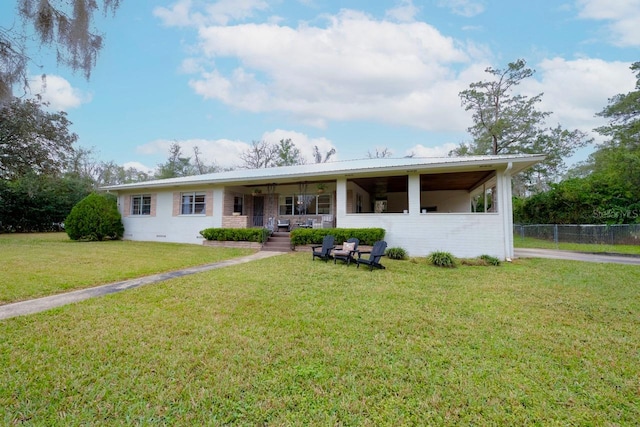 ranch-style home with covered porch and a front yard