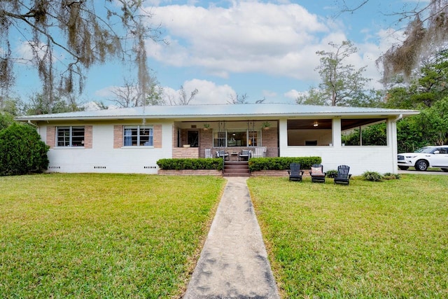 ranch-style house featuring covered porch and a front lawn