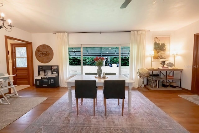 dining area featuring hardwood / wood-style flooring and an inviting chandelier