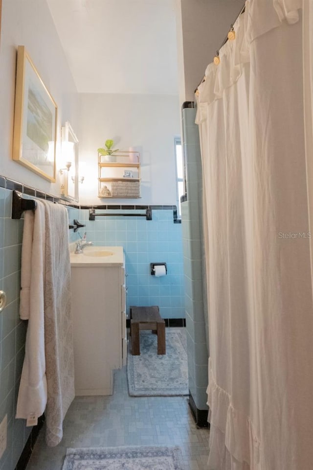 bathroom featuring tile walls, vanity, and a shower with curtain