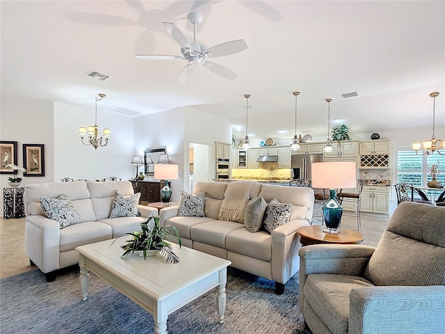 living room with ceiling fan with notable chandelier and visible vents