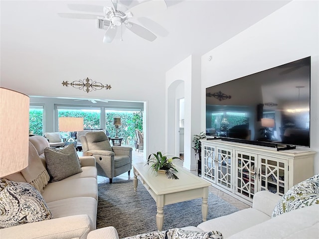 living room with a ceiling fan and arched walkways