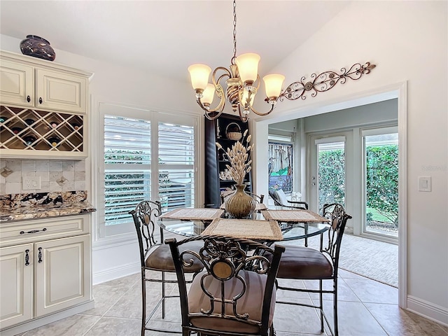 dining area featuring vaulted ceiling, an inviting chandelier, and light tile patterned floors