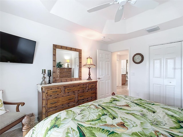 bedroom featuring ceiling fan, visible vents, a raised ceiling, and a closet