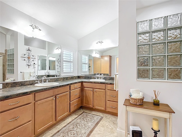 full bathroom featuring lofted ceiling, tile patterned flooring, a sink, and double vanity