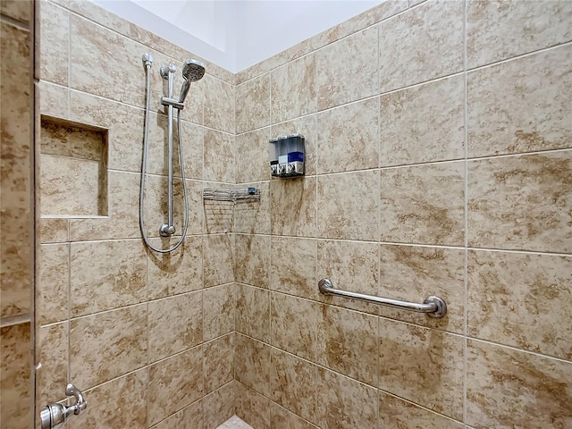 interior details featuring tiled shower