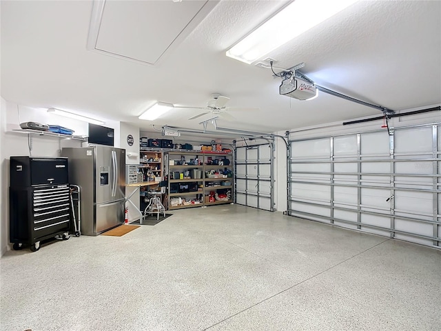 garage featuring a garage door opener, a ceiling fan, and stainless steel fridge with ice dispenser