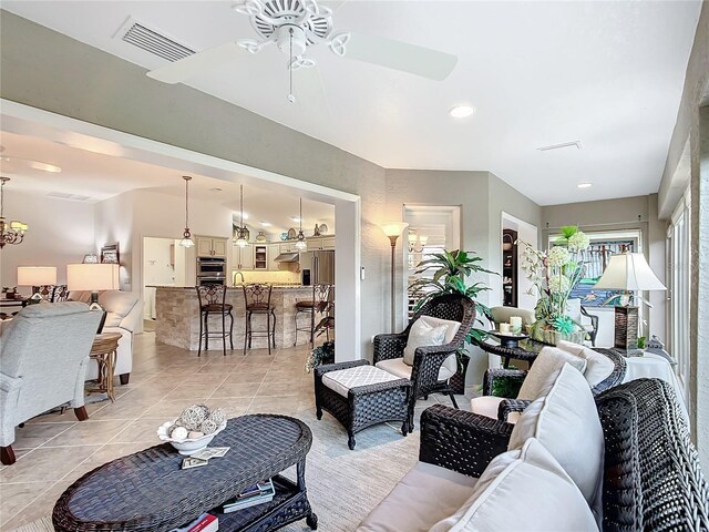 living room featuring light tile patterned floors, visible vents, and a ceiling fan