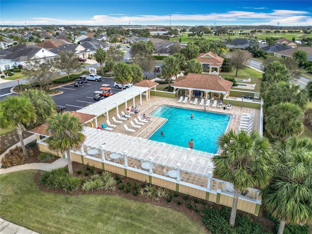 community pool featuring a patio area, fence, and a residential view