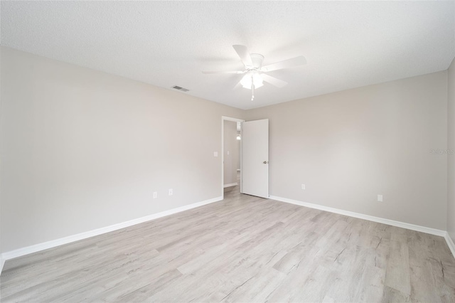 unfurnished room with a ceiling fan, baseboards, a textured ceiling, and light wood finished floors