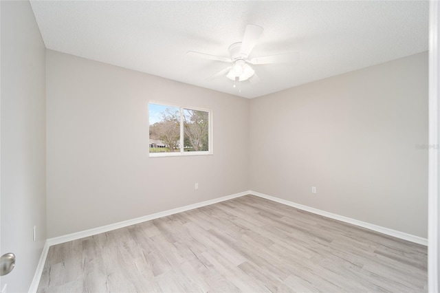 unfurnished room with light wood finished floors, baseboards, and a ceiling fan