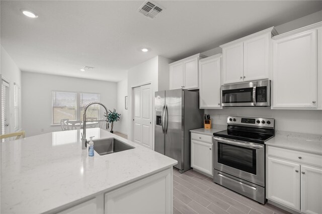 7374 SW 77th Ave, Ocala, FL 34481 - kitchen featuring appliances with stainless steel finishes, a sink, white cabinetry, recessed lighting, and light stone countertops