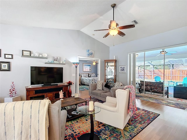 living area featuring visible vents, a sunroom, ceiling fan, wood finished floors, and vaulted ceiling