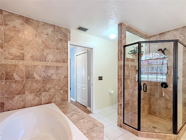 full bathroom featuring a textured ceiling, visible vents, tile patterned floors, a whirlpool tub, and a stall shower