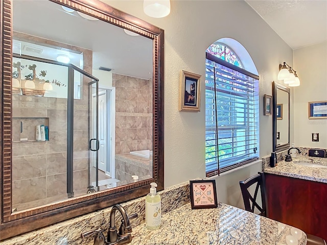 bathroom with a stall shower, a wealth of natural light, visible vents, and vanity