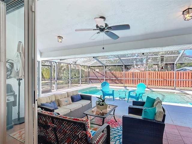 view of patio / terrace with glass enclosure, a fenced backyard, a ceiling fan, an outdoor living space, and a fenced in pool