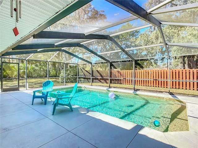 view of swimming pool with glass enclosure, a patio area, a fenced backyard, and a fenced in pool