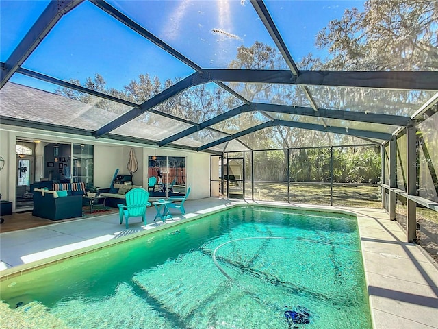 outdoor pool featuring glass enclosure, a patio area, and an outdoor living space