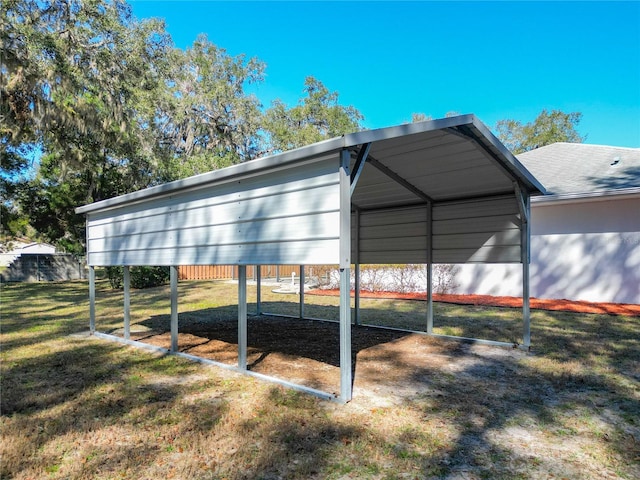 view of outdoor structure featuring a carport and fence