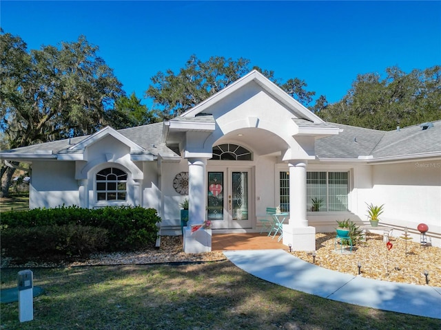 view of front of home featuring a shingled roof, french doors, and stucco siding