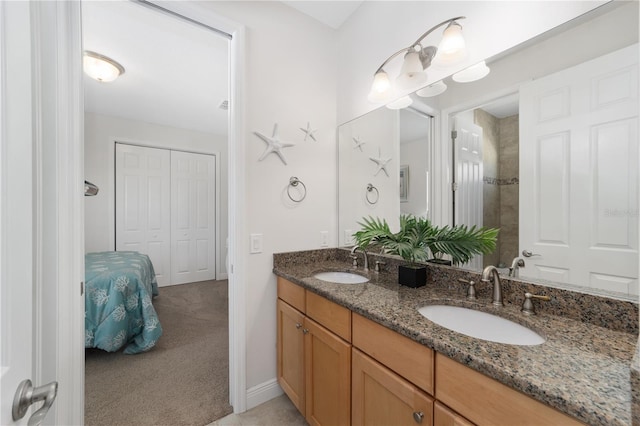 bathroom featuring connected bathroom, a sink, baseboards, and double vanity