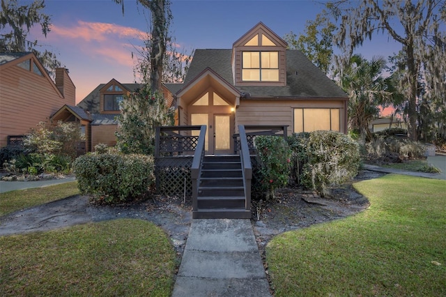 view of front of house with a front yard, stairway, and a wooden deck