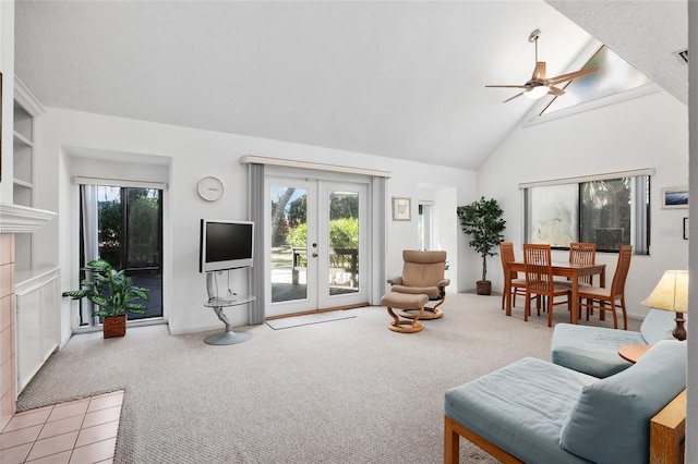 living area with high vaulted ceiling, french doors, light carpet, and ceiling fan