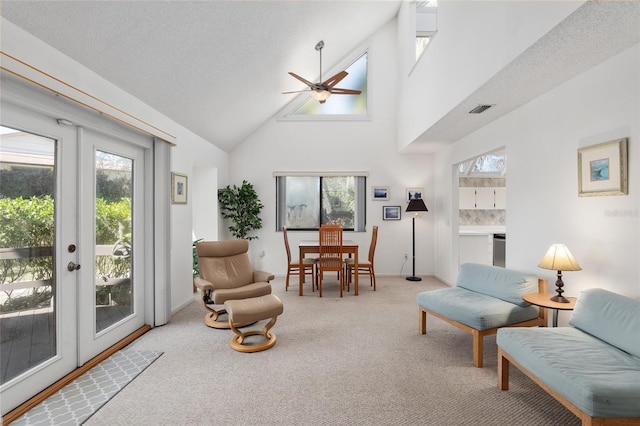 living area featuring visible vents, ceiling fan, french doors, carpet floors, and high vaulted ceiling