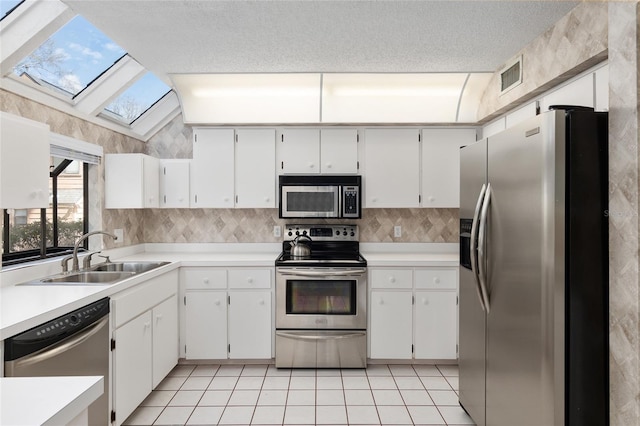 kitchen featuring a sink, stainless steel appliances, light countertops, and white cabinets