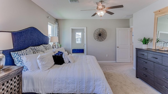 bedroom featuring baseboards, ceiling fan, visible vents, and light colored carpet