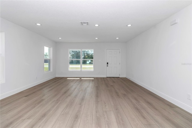 unfurnished living room with recessed lighting, baseboards, visible vents, and light wood finished floors