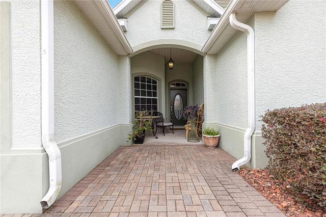 doorway to property featuring stucco siding