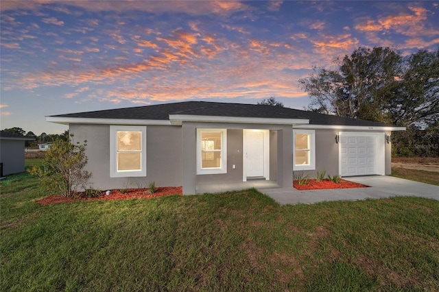 single story home featuring concrete driveway, a lawn, an attached garage, and stucco siding