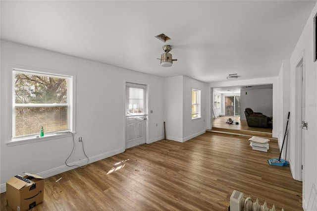 foyer with wood finished floors, visible vents, and baseboards