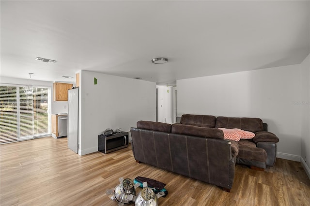 living area with visible vents, light wood-style flooring, and baseboards